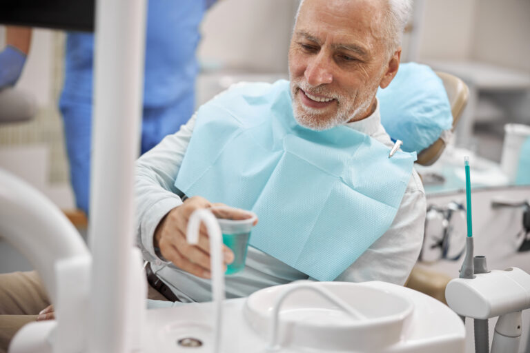 älterer Mann beim Zahnarzt, oralchirugischer Eingriff